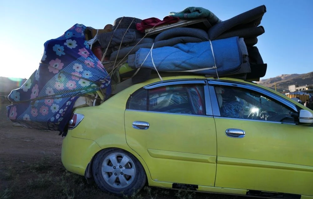 A Syrian refugee woman sits inside a car, as she prepares to go back home to Syria as a part of a voluntary return, in the eastern Lebanese border town of Arsal, Tuesday, May 14, 2024. (AP Photo)