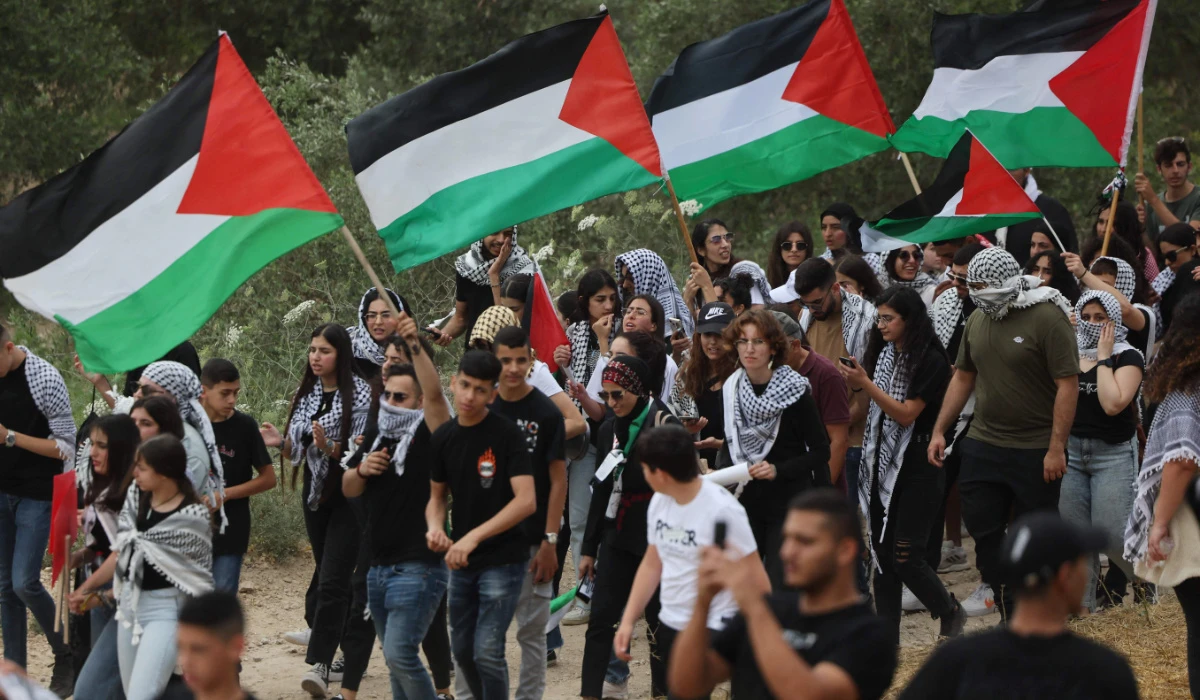 Arab-Israeli protesters wave Palestinian national flags during a rally near Israel's northern city of Shefa Amr, on May 14, 2024, ahead of the Palestinian marking of the 76th anniversary of the Nakba, the "catastrophe" of Israel's creation in 1948. (AFP)
