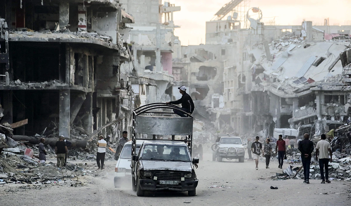 Displaced Palestinians drive their vehicles along a street devastated by Israeli bombardment in Khan Yunis in the southern Gaza Strip on May 15, 2024, amid the ongoing conflict between Israel and the Hamas group. (AFP)