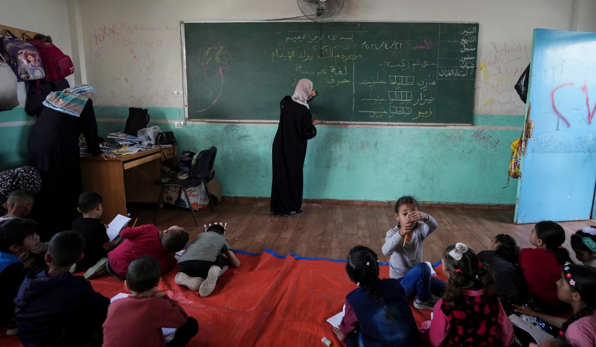 Manal Al Buhaisi works with children at a makeshift class in Deir al Balah, on Sunday, April 21, 2024. (AP)