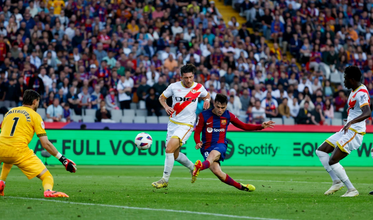 Barcelona's Pedri, right, scores his side's third goal during a Spanish La Liga soccer match between Barcelona and Rayo Vallecano at the Olimpic Lluis Companys stadium in Barcelona Sunday. (AP)