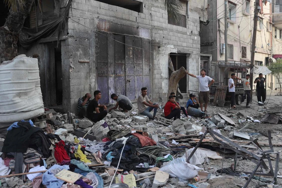 Palestinians sit by the rubble of a family house that was hit overnight in Israeli bombardment in the Tal Al-Sultan neighborhood of Rafah in southern Gaza on May 20, 2024. (AFP)