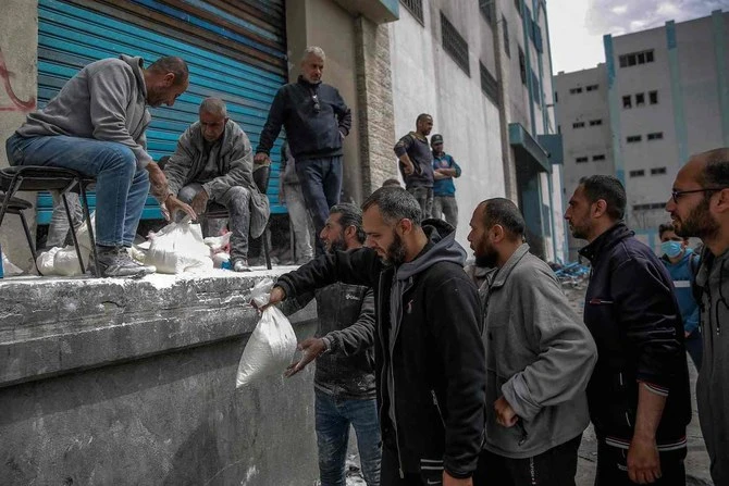 A man hands out bags of flour during the distribution of humanitarian aid in Gaza City on March 17, 2024. (AFP/File)
