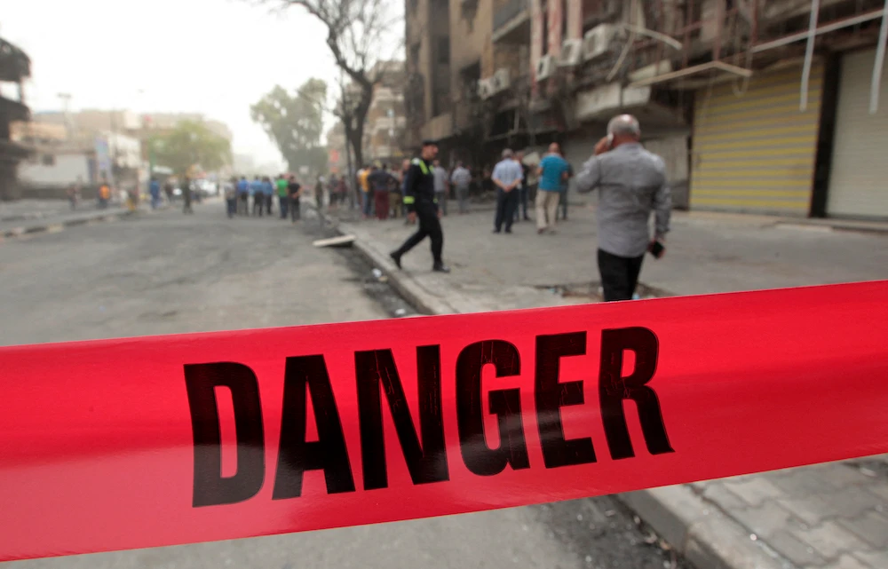 Iraqis inspect a site secured with police red tape in Baghdad. (File/AFP)