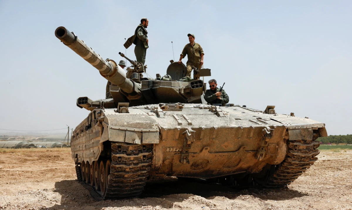 Israeli soldiers operate atop a tank near the Israel-Gaza border, amid the ongoing conflict between Israel and the Palestinian Islamist group Hamas, as seen from Israel, May 21, 2024. (Reuters)