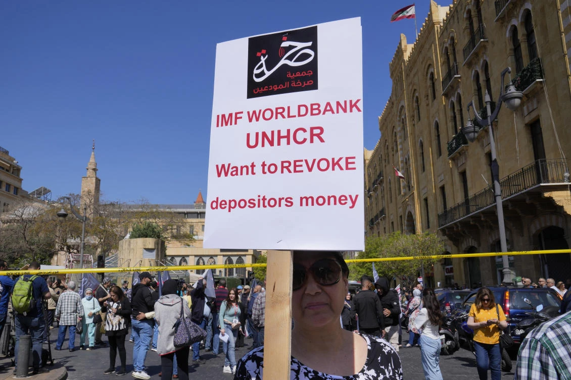 A protesting depositor carries a placard at a protest near Parliament in downtown Beirut on May 9, 2023. (AP/File)