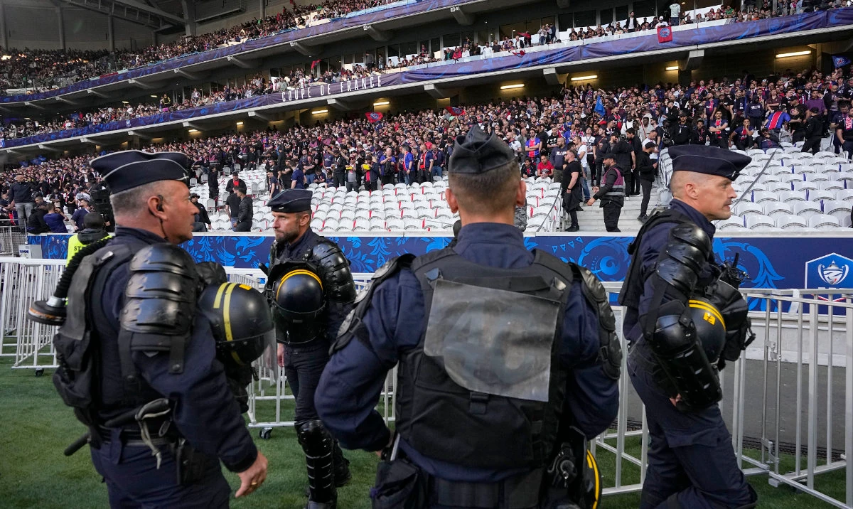 French riot police officers stand on the side of the pitch before the French Cup final soccer match between Lyon and PSG at the Pierre Mauroy stadium in Villeneuve d'Ascq, northern France, Saturday, May 25, 2024. (AP)
