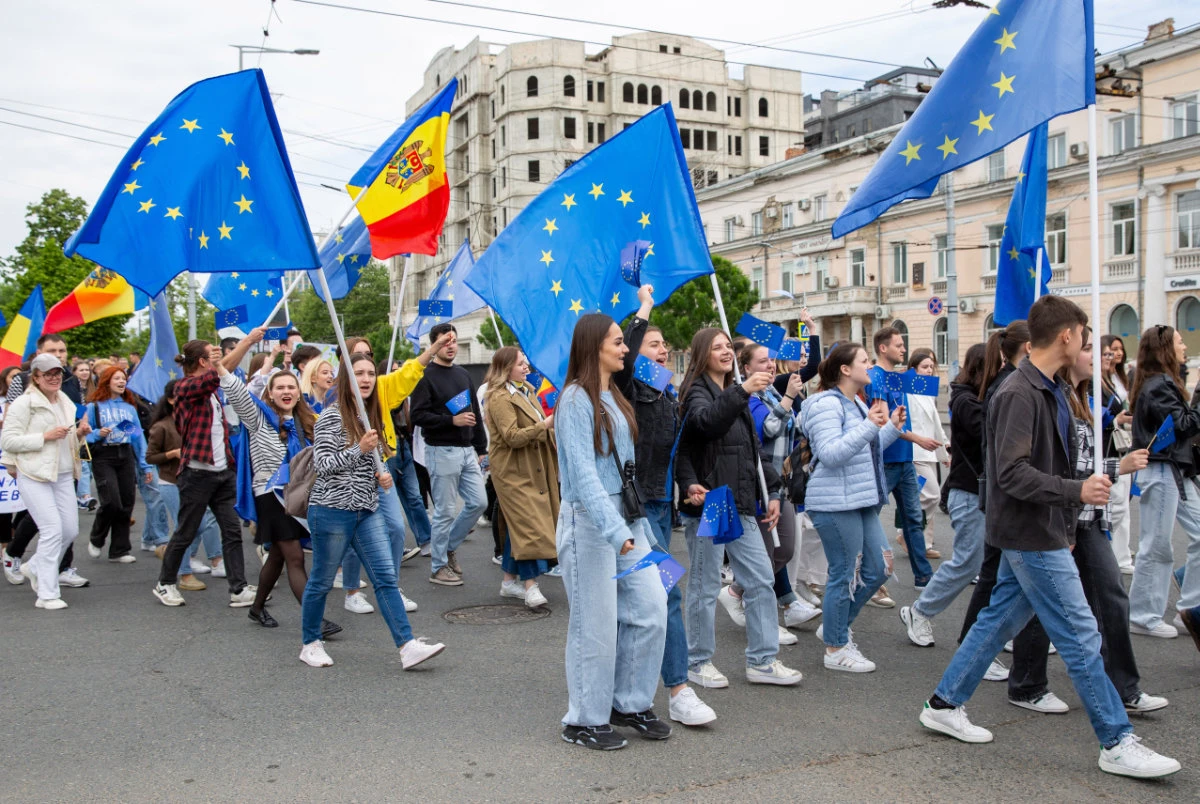 Young Moldovans waving EU and Moldovan flags take part during a march downtown Chisinau to celebrate Europe Day on May 9, 2024. (AFP)