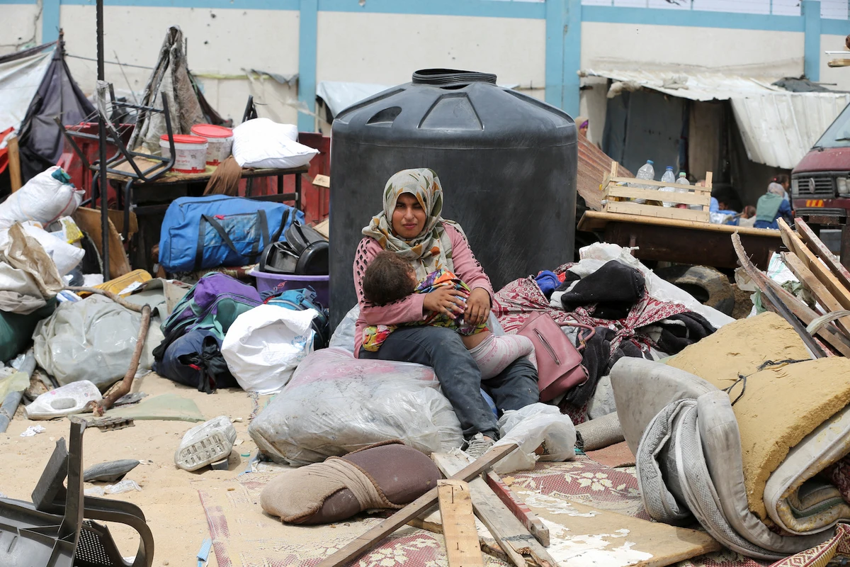 A woman sits with a child in Rafah, in the southern Gaza Strip, May 28, 2024. (Reuters)