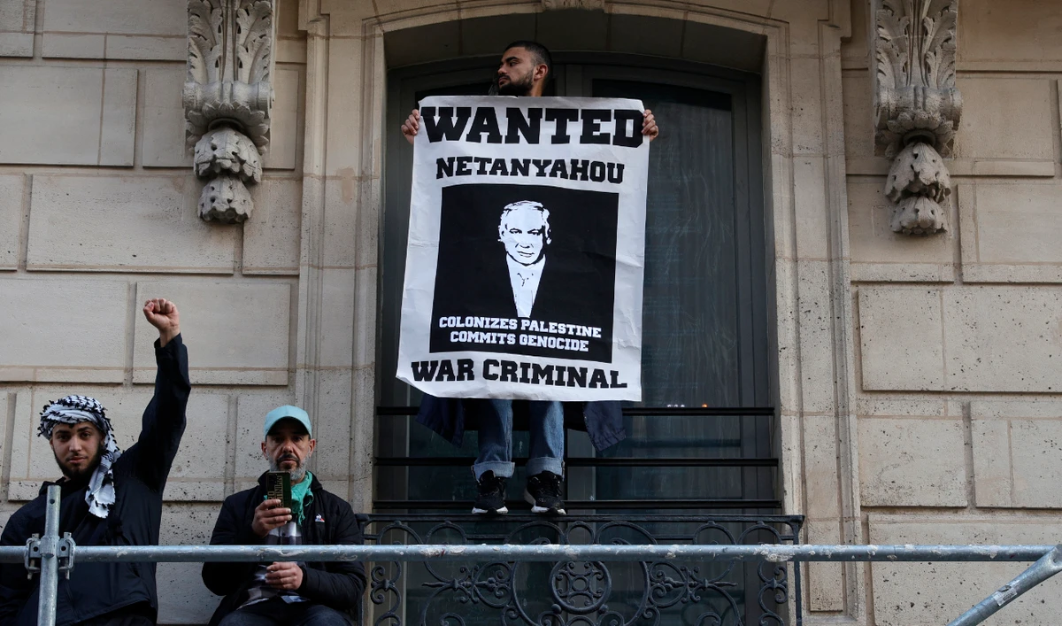 A protestor holds a poster bearing a wanted announcement for Israeli Prime Minister Benjamin Netanyahu during a demonstration in Paris on May 27, 2024 to protest an overnight Israeli strike on a camp in Rafah for internally displaced Palestinians. (AFP/File)