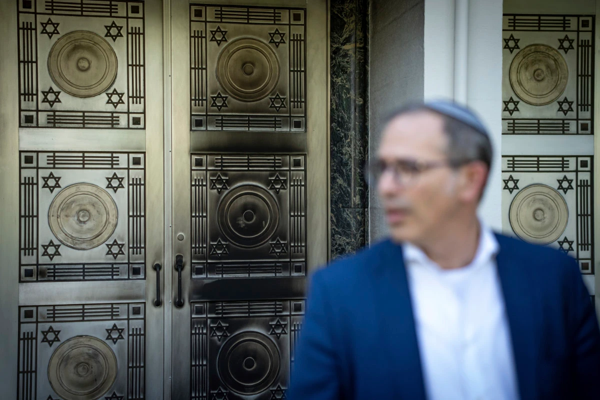 A metal plated on a door at the Schara Tzedeck synagogue is blackened as Rabbi Andrew Rosenblatt speaks to media on May 31, 2024, in Vancouver, British Columbia. (The Canadian Press via AP)