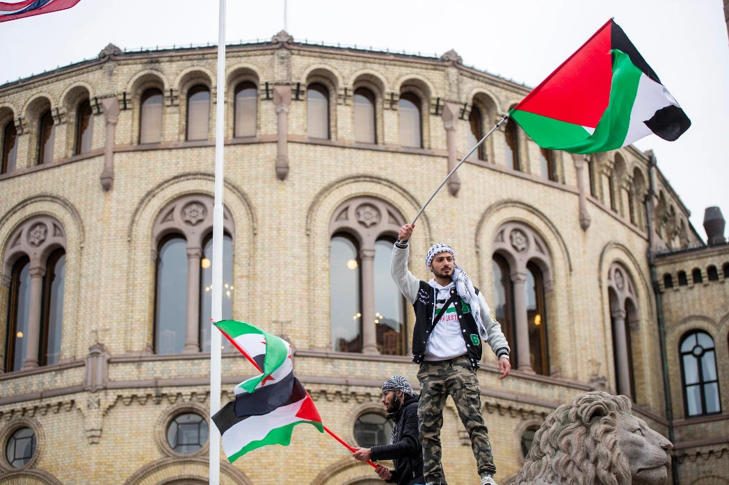 A man waves the Palestinian flag in front of the Norwegian Parliament building during a demonstration in Oslo. (AP)