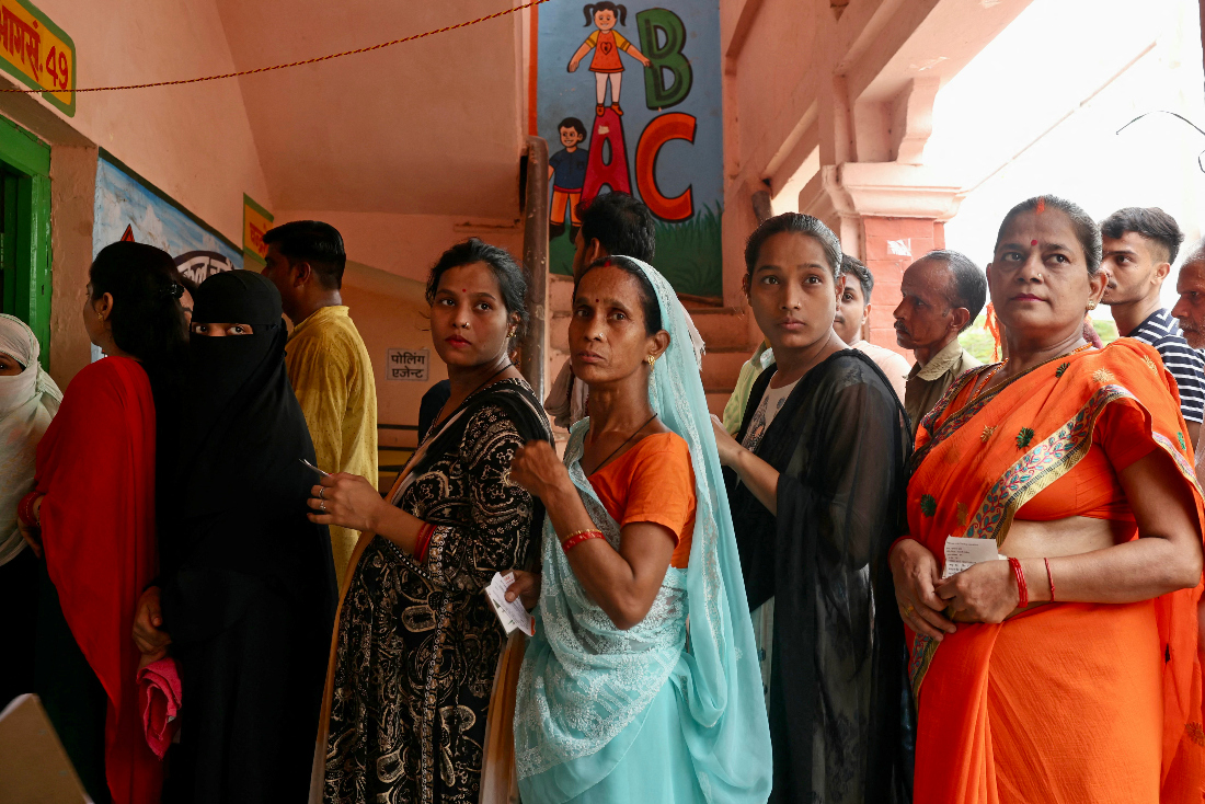 Voters queue up to cast their ballots at a polling station in Varanasi on June 1, 2024, during the seventh and final phase of voting in India's general election. (AFP)