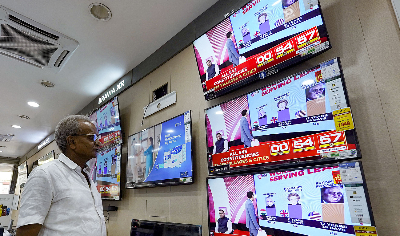A man watching television waits for the release of exit polls published after voting concludes during its seventh and final phase amid India’s general election, at an appliance store in Ajmer on June 1, 2024. (AFP)