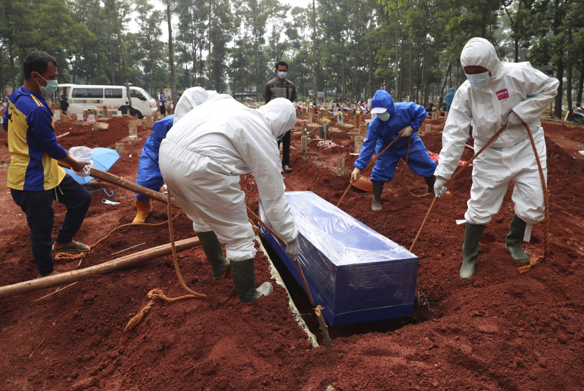 Workers in protective gear lower a coffin of a COVID-19 victim to a grave for burial at the Cipenjo Cemetery in Bogor, West Java, Indonesia, on July 14, 2021. The World Health Organization says member countries on Saturday, June 1, 2024, approved a series of new steps to improve global preparedness for and response to pandemics like COVID-19 and mpox. (AP/File)