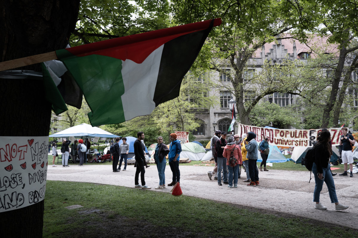 In this photo taken on on May 03, 2024, a Palestinian flag flies near a group of activists at an encampment protesting the war in Gaza on the campus of the University of Chicago in , Illinois. (Getty Images/AFP)