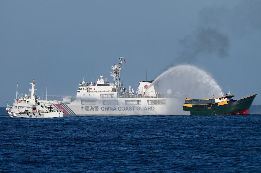 China Coast Guard vessels deploy water cannons at the Philippine-chartered Unaizah May 4 during its supply mission to Second Thomas Shoal in the disputed South China Sea on March 5, 2024. (AFP)