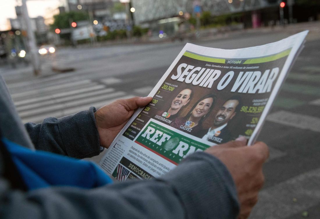 A man reads a newspaper a while before the start of the general election, in Mexico City, on June 2, 2024. (AFP)