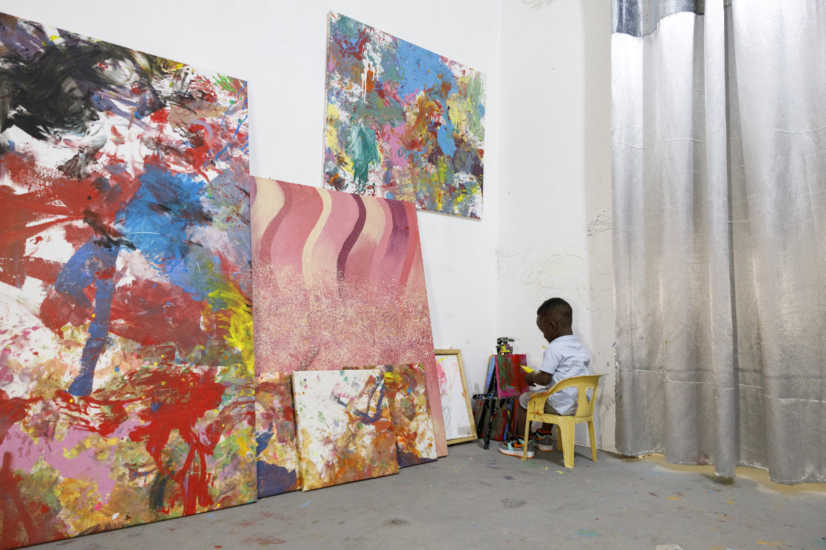 Ace-Liam Nana Sam Ankrah, who will turn two in July, paints amidst his own art work at his mother's art gallery in Accra, Ghana,on May 27, 2024. (AP Photo/Misper Apawu)