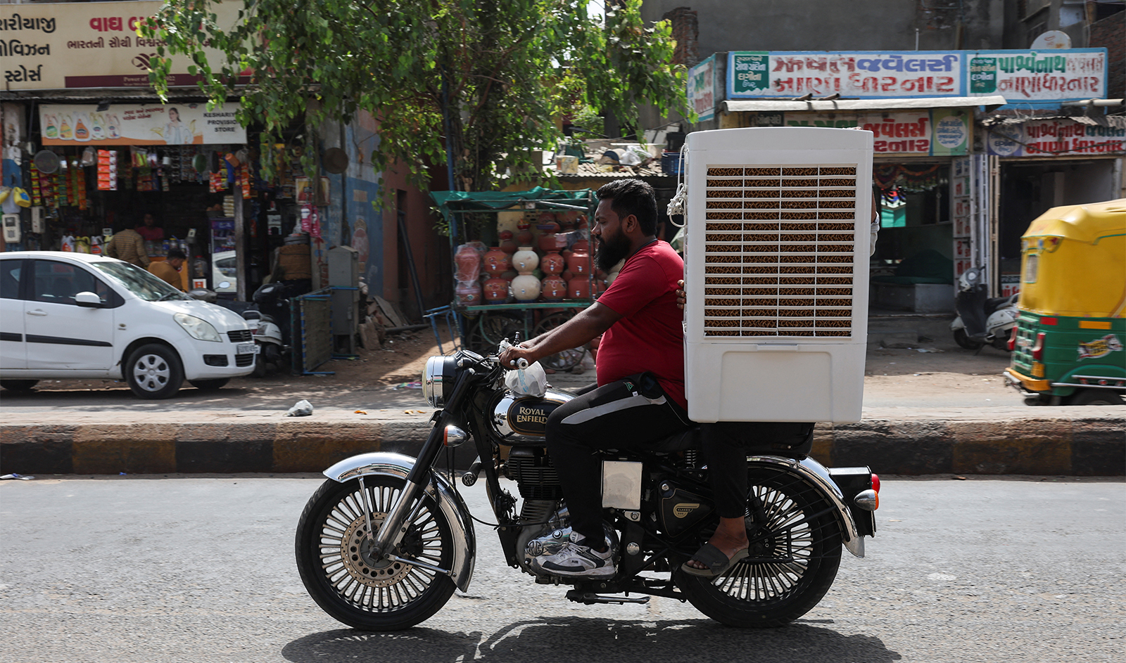 A man transports an air cooler on a motorcycle during a heat wave in Ahmedabad, India, on May 30, 2024. (REUTERS)