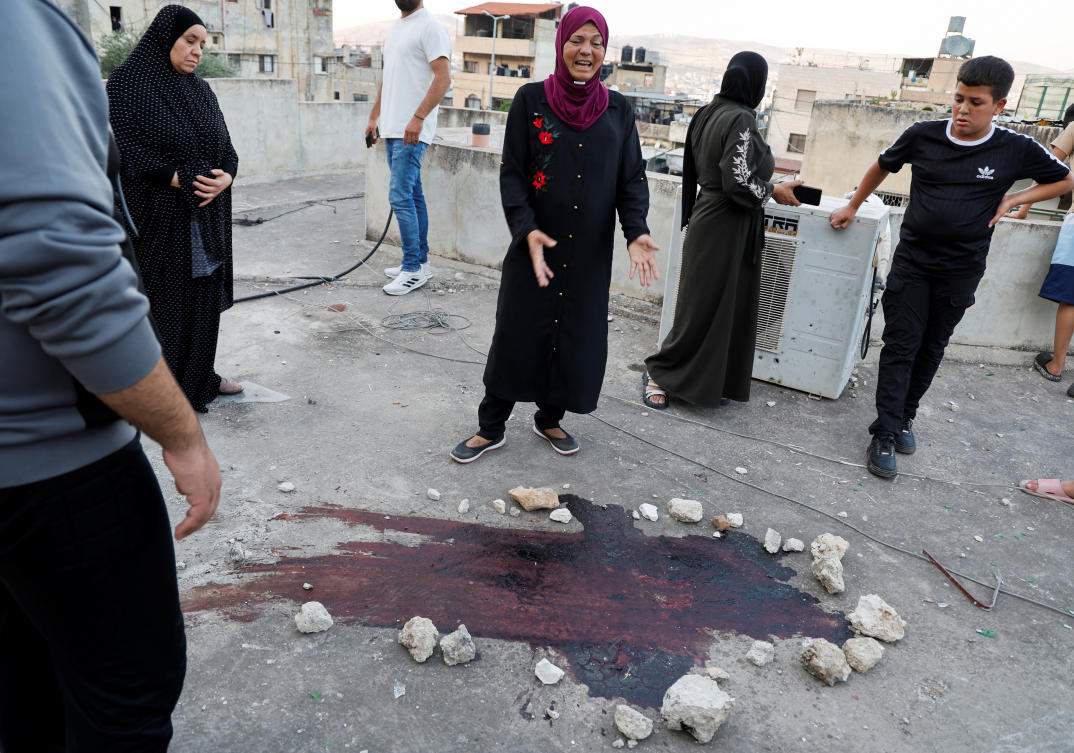 A Palestinian woman reacts next to a blood stain on the day of an Israeli raid in Balata camp, in Nablus, the Israeli-occupied West Bank, June 3, 2024. (Reuters)