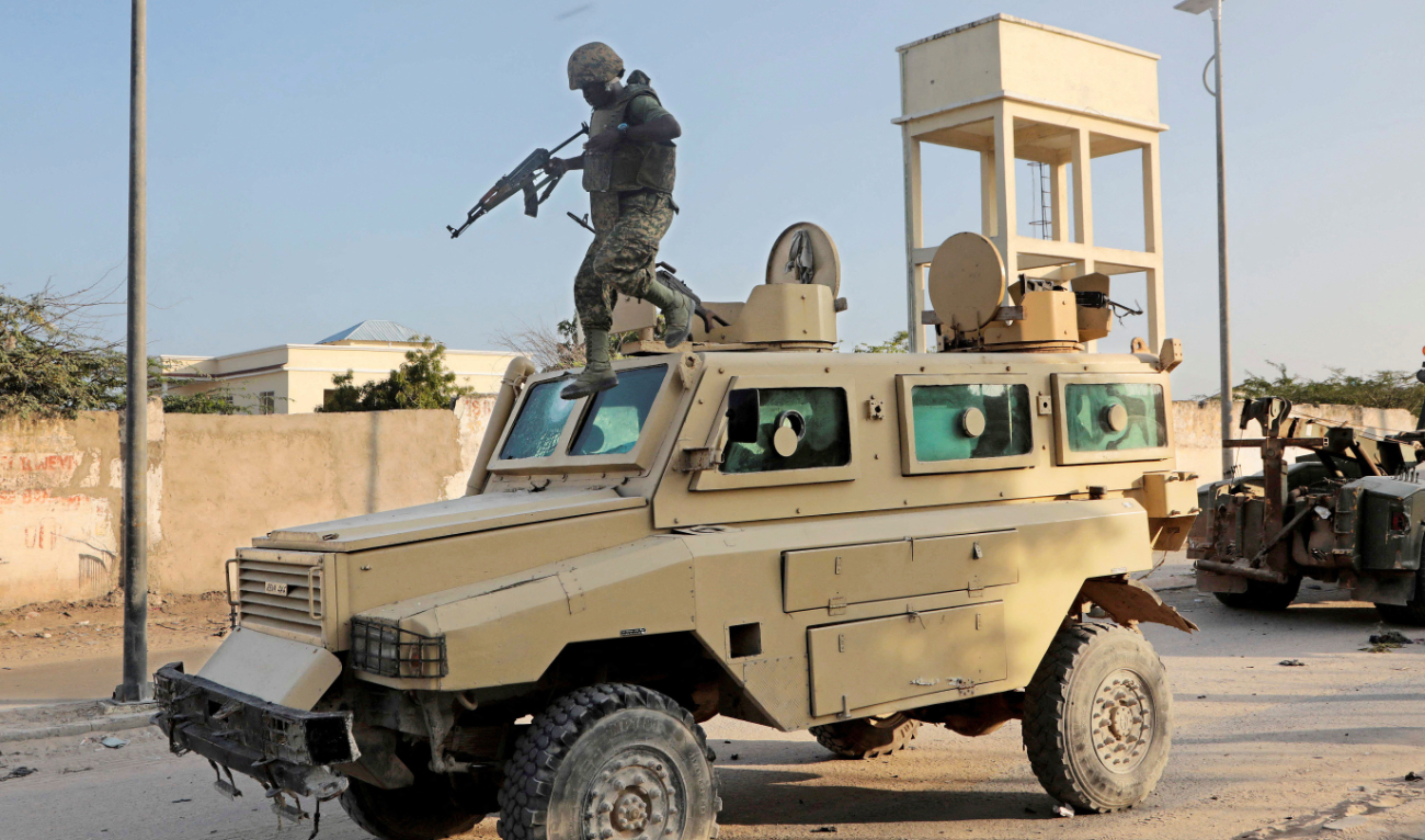 A soldier serving in the African Union Mission in Somalia jumps off a military vehicle near the scene of an explosion in Mogadishu. (Reuters)