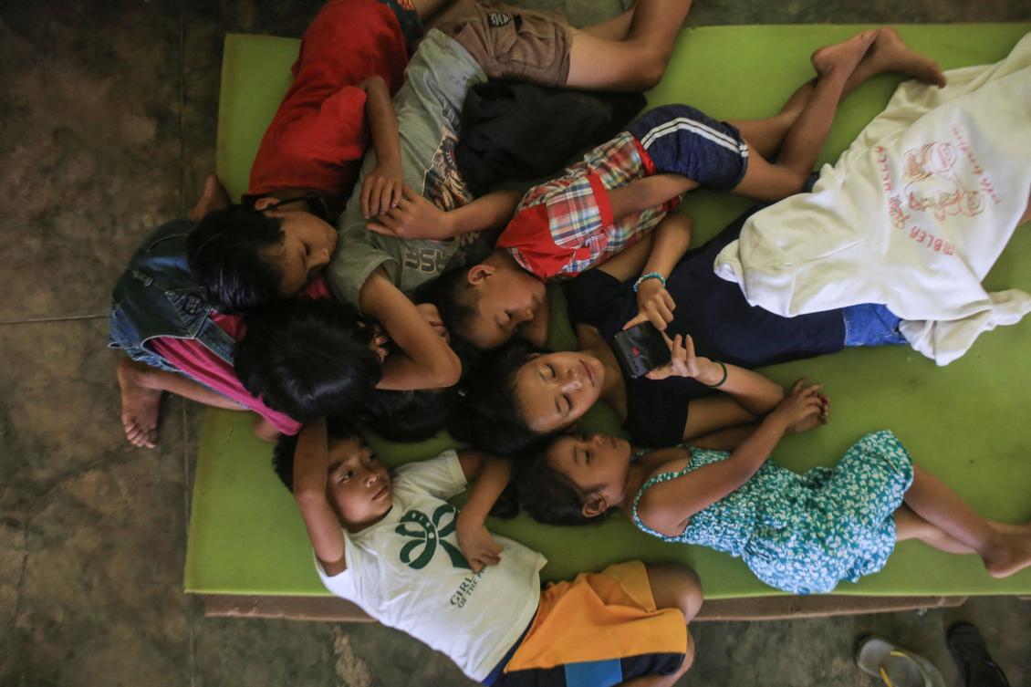 Evacuees rest inside an evacuation center set up at a school in a village in Canlaon, Negros Occidental province, central Philippines on Jun. 4, 2024. (AFP)