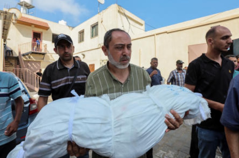A mourner carries the body of a Palestinian child killed in an Israeli strike at Al-Aqsa hospital in Deir Al-Balah on Jun. 4, 2024. (Reuters)