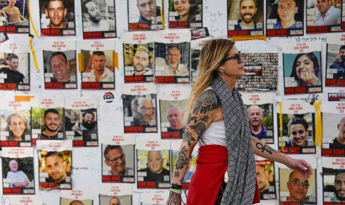 A woman walks past pictures of hostages in Tel Aviv, Israel, on Feb. 12, 2024. (AP)