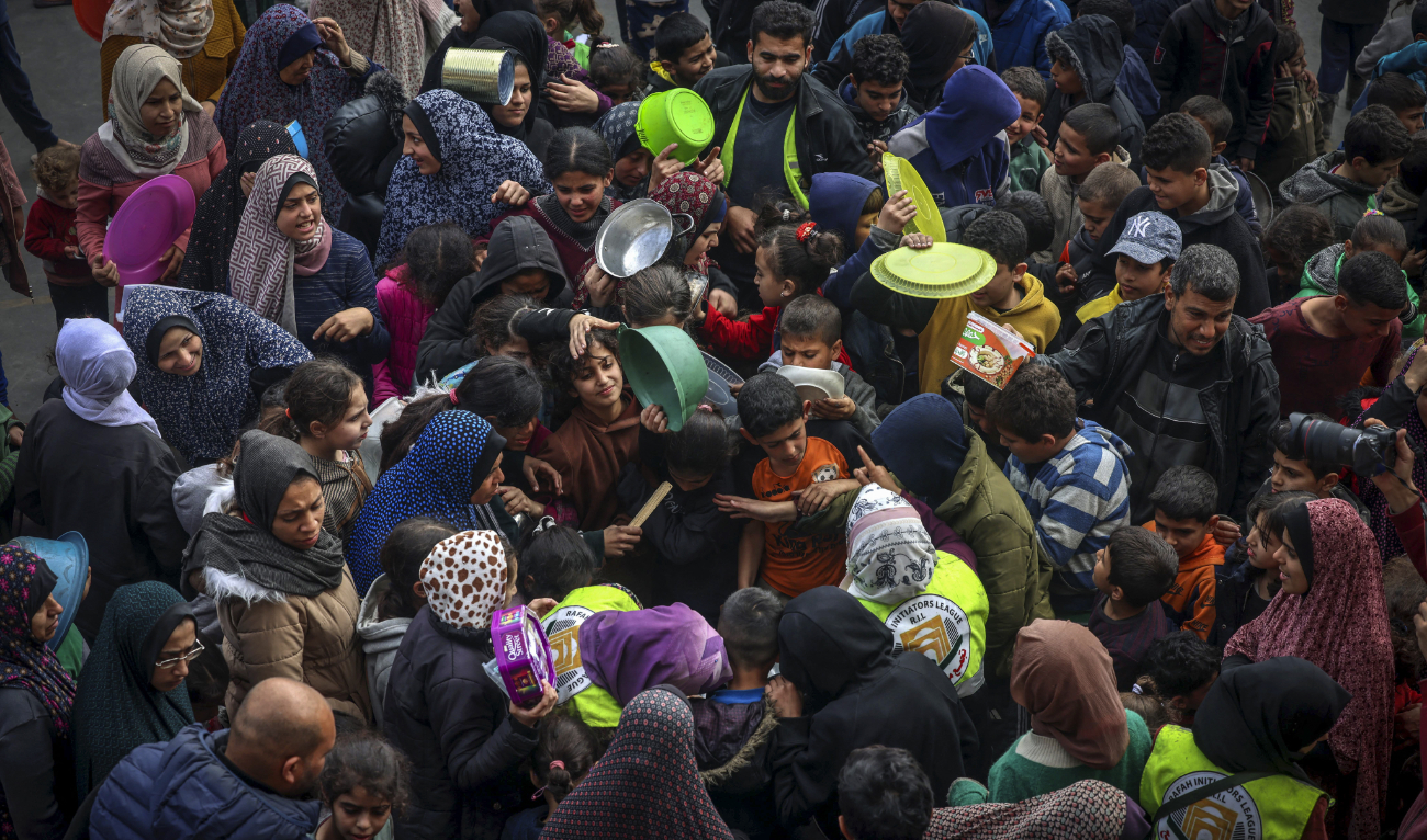 Displaced Palestinians gather to receive food at a government school in Rafah in the southern Gaza Strip on February 19, 2024. (AFP/File)