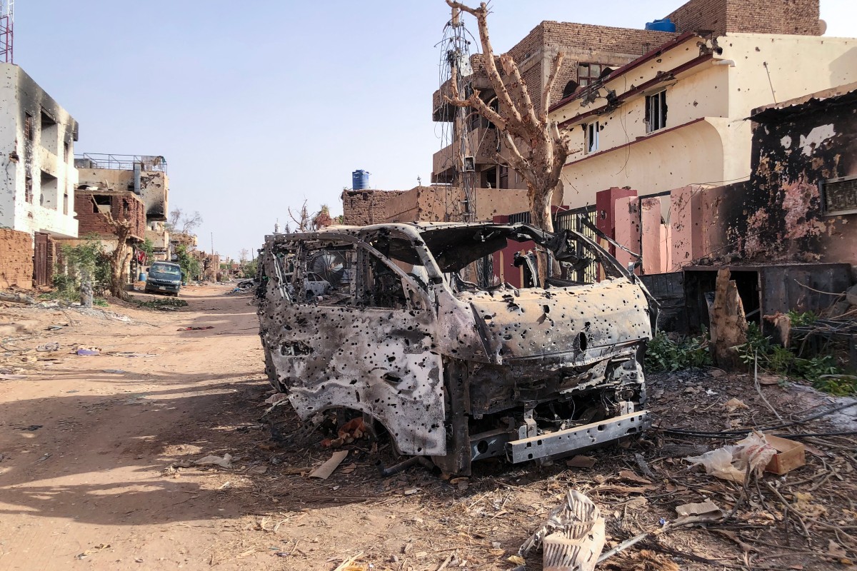 This picture taken on May 30, 2024, shows a burnt vehicle in front of damaged shop in Omdurman. War has raged for more than a year in Sudan between the regular military under army chief Abdel Fattah al-Burhan and the paramilitary Rapid Support Forces led by his former deputy Mohamed Hamdan Daglo (AFP)