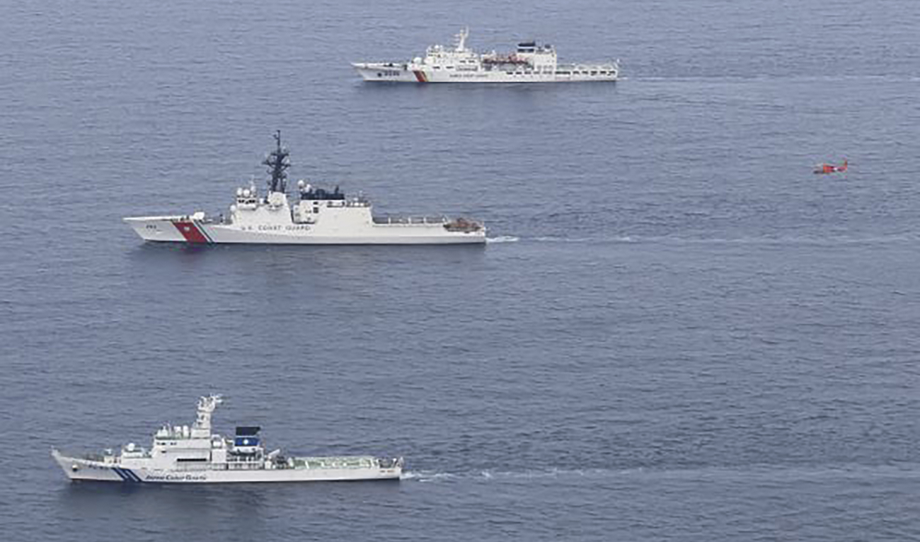 Japan’s patrol vessel Wakasa, from bottom, US Coast Guard’s cutter Waesche and South Korea Coast Guard’s patrol vessel Taepyongyang 16 as a helicopter (in red) flies at right during a drill in waters off the northern coast of Maizuru, Japan, Thursday, June 6, 2024. (AP)