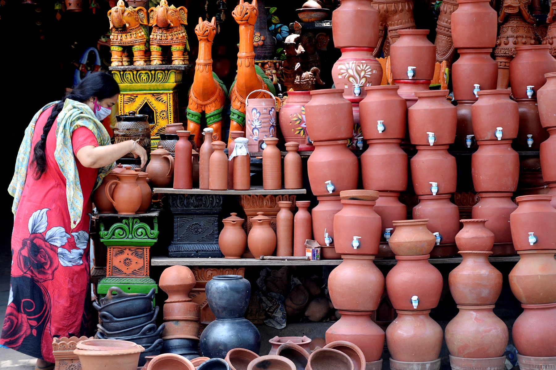 A vendor arranges earthen pots for sale along a sidewalk in Chennai on June 5, 2020. (AFP)