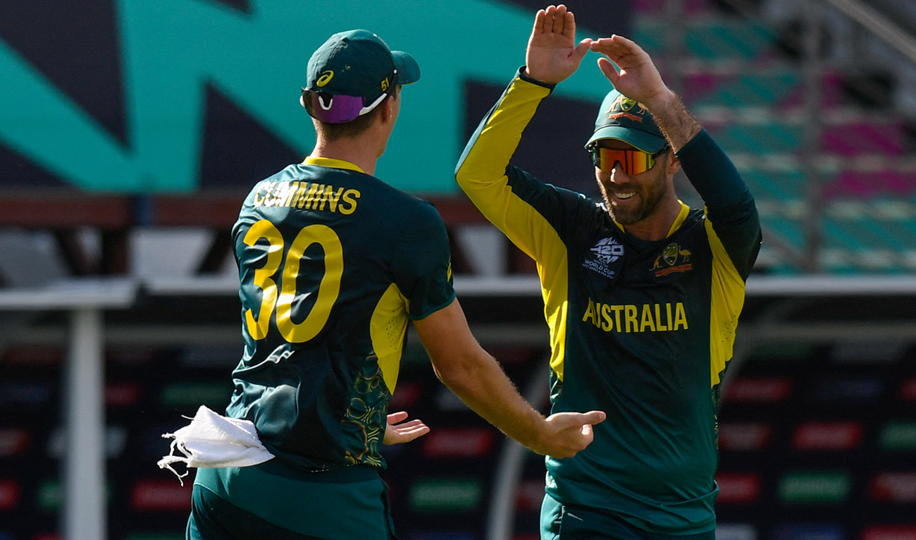 Australia's Glenn Maxwell (R) and Australia's Pat Cummins celebrate the dismissal of England's Jonathan Bairstow during the ICC men's Twenty20 World Cup 2024 group B cricket match between Australia and England at Kensington Oval in Bridgetown, Barbados, on June 8, 2024. (AFP)