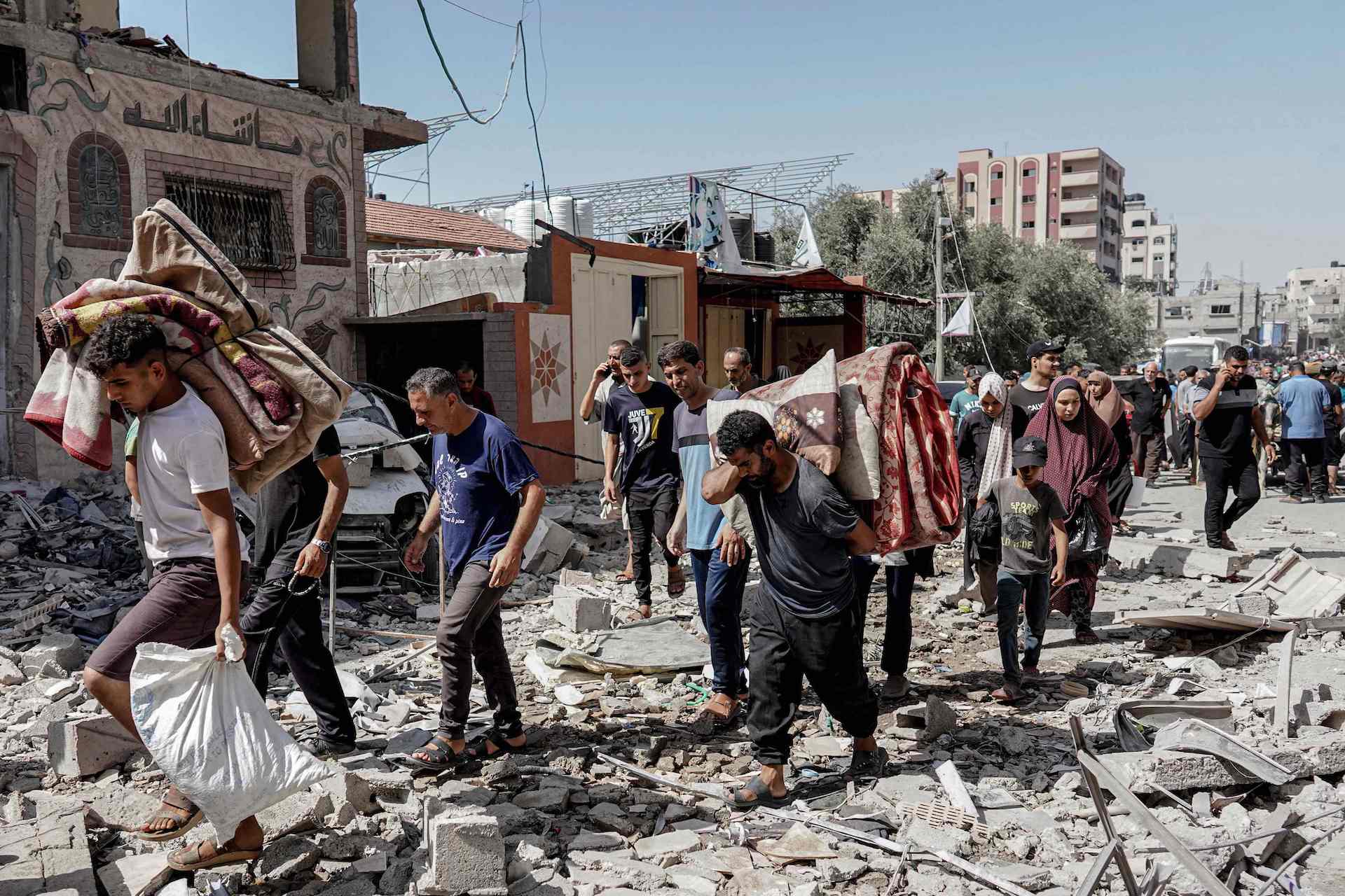 Palestinians evacuate with their belongings following an operation by the Israeli Special Forces in the Nuseirat camp, in the central Gaza Strip on June 8, 2024. (AFP)