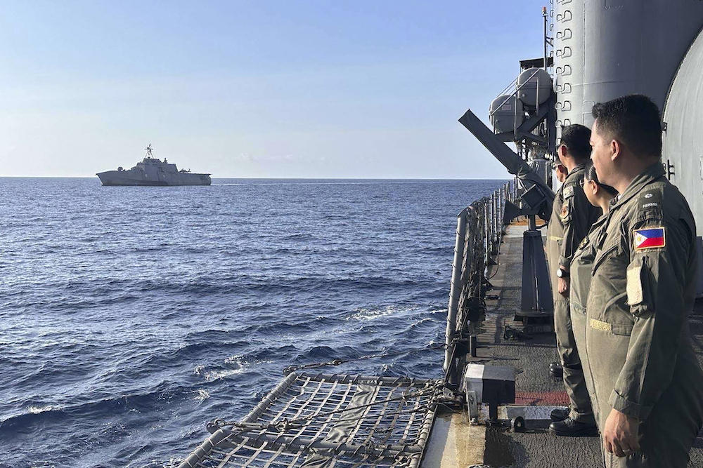The USS Gabrielle Giffords receives passing honors by Philippine navy officers aboard BRP Gregorio Del Pilar, a naval tradition rendered to ships passing close aboard, on Feb. 9, 2024. (Armed Forces of the Philippines’ Western Command/AFP)