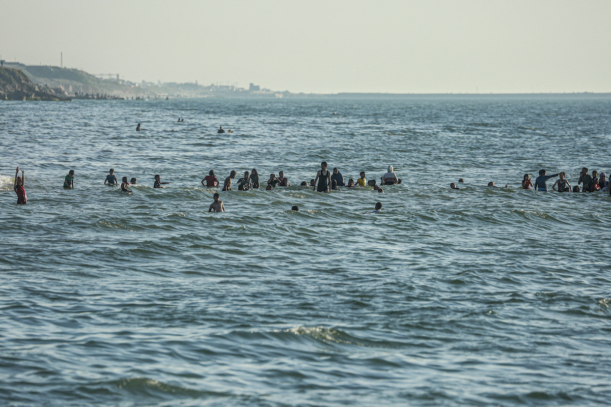 Palestinians swim in the sea in Deir el-Balah in the central Gaza Strip on April 17, 2024. (File/AFP)