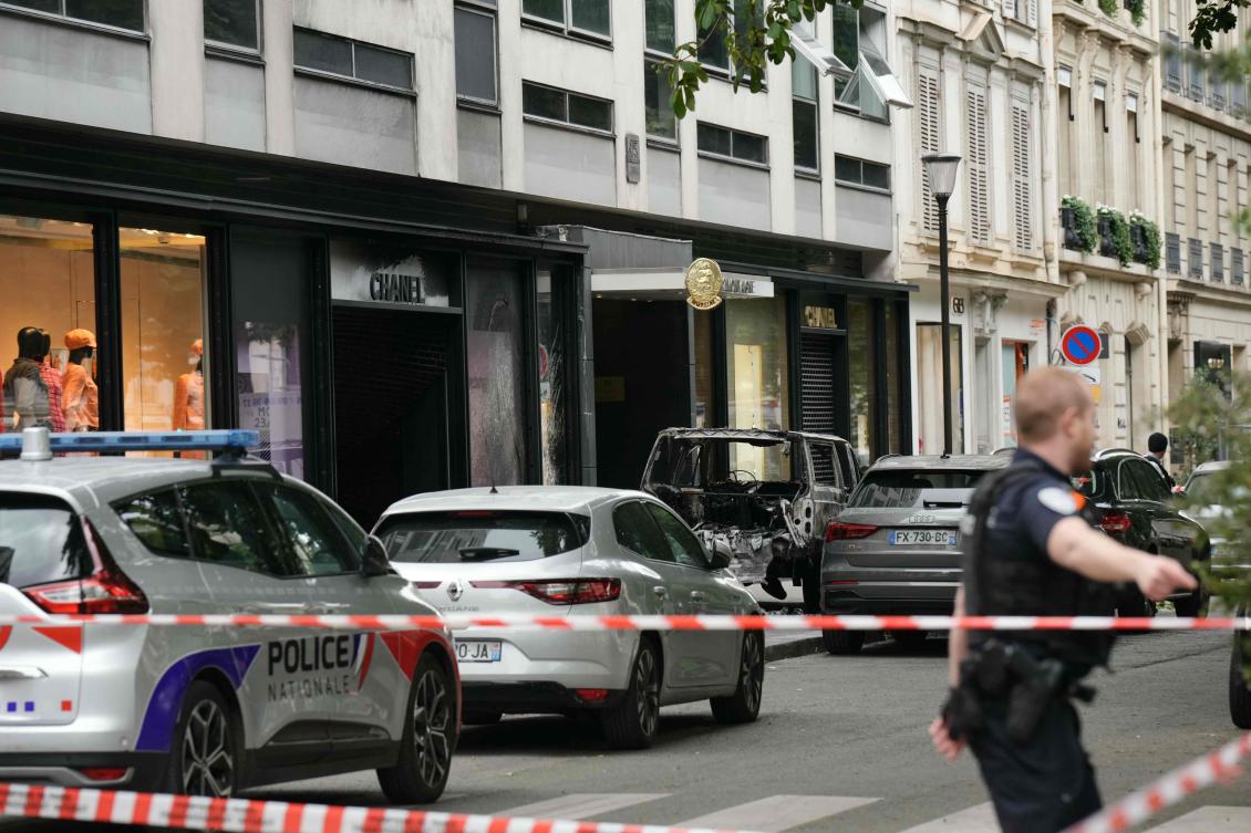 A police officer cordons off a street after a Chanel boutique was attacked with a ram car by a team of escaped robbers on June 10, 2024. (AFP)