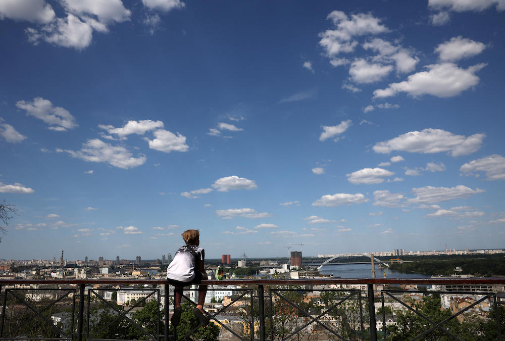 Above, a child looks at the Dnipro river from a park in Kyiv on May 27, 2024. (AFP)