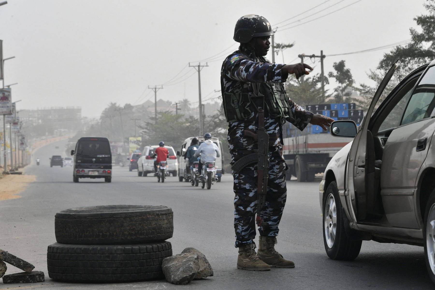 A police officer stops a car at a check point to check the activities of criminals and unknown gunmen ahead of the February 25 presidential election at Awka in Anambra State, southeast Nigeria, on February 16, 2023. (AFP)