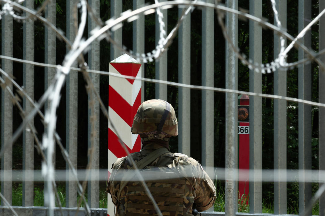 A soldier stands guard near the fence on the Belarusian-Polish border in the forest near Bialowieza, Poland, June 4, 2024. (Reuters)