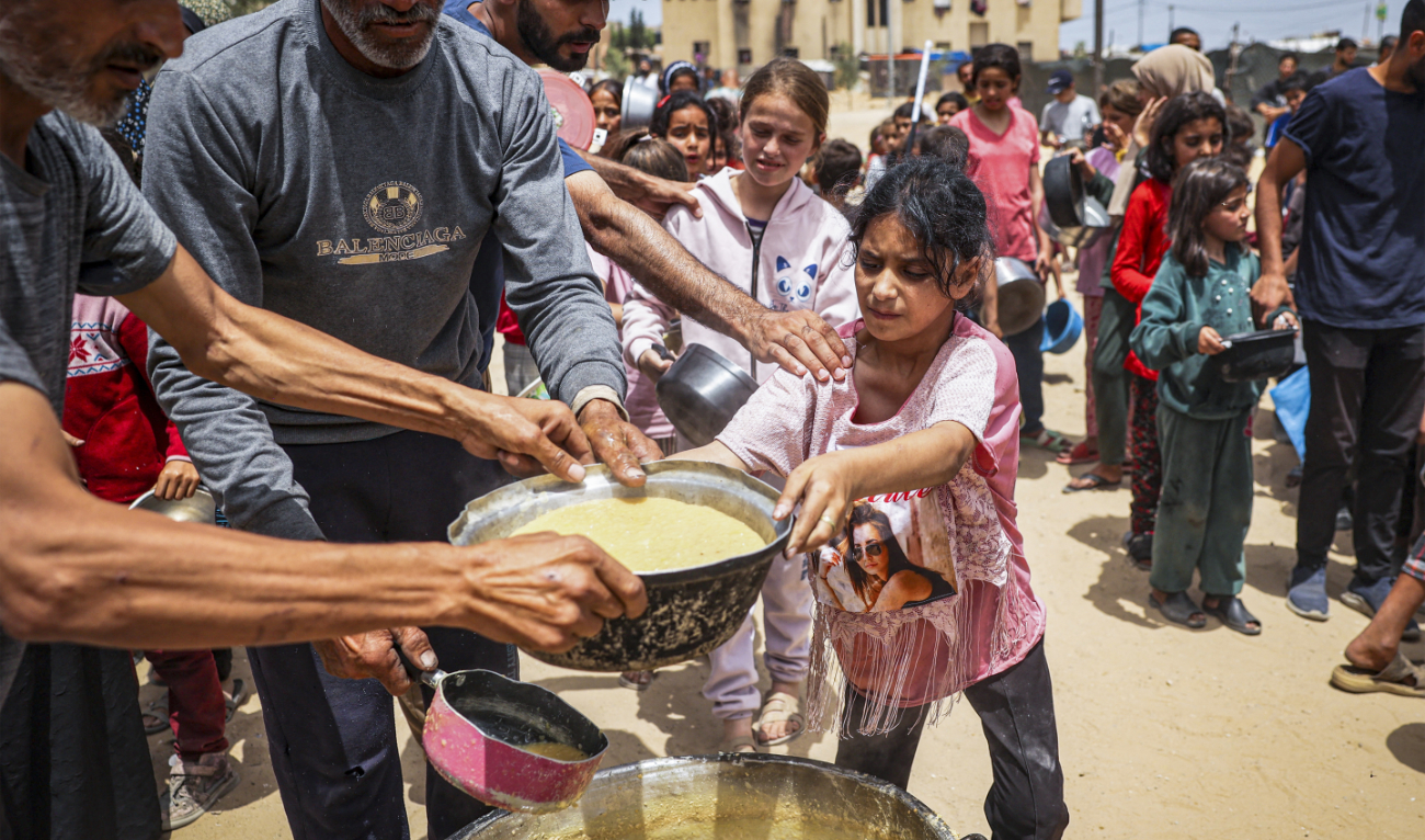 Displaced Palestinian children line up to receive food in Rafah, in the southern Gaza Strip, on May 19, 2024. (AFP)