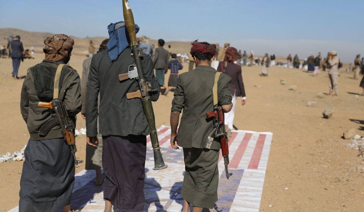 Tribesmen loyal to the Houthis walk on US and Israeli flags at the site of a parade for new tribal recruits amid escalating tensions with the US-led coalition in the Red Sea, in Bani Hushaish, Yemen January 22, 2024. (REUTERS)