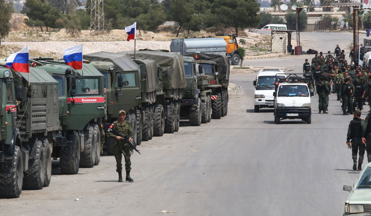 Syrian and Russian soldiers wait at the entrance of the Wafideen Camp for the arrival of buses carrying Jaish al-Islam fighters and their family members evacuated from the Eastern Ghouta town of Douma. (AFP file photo)