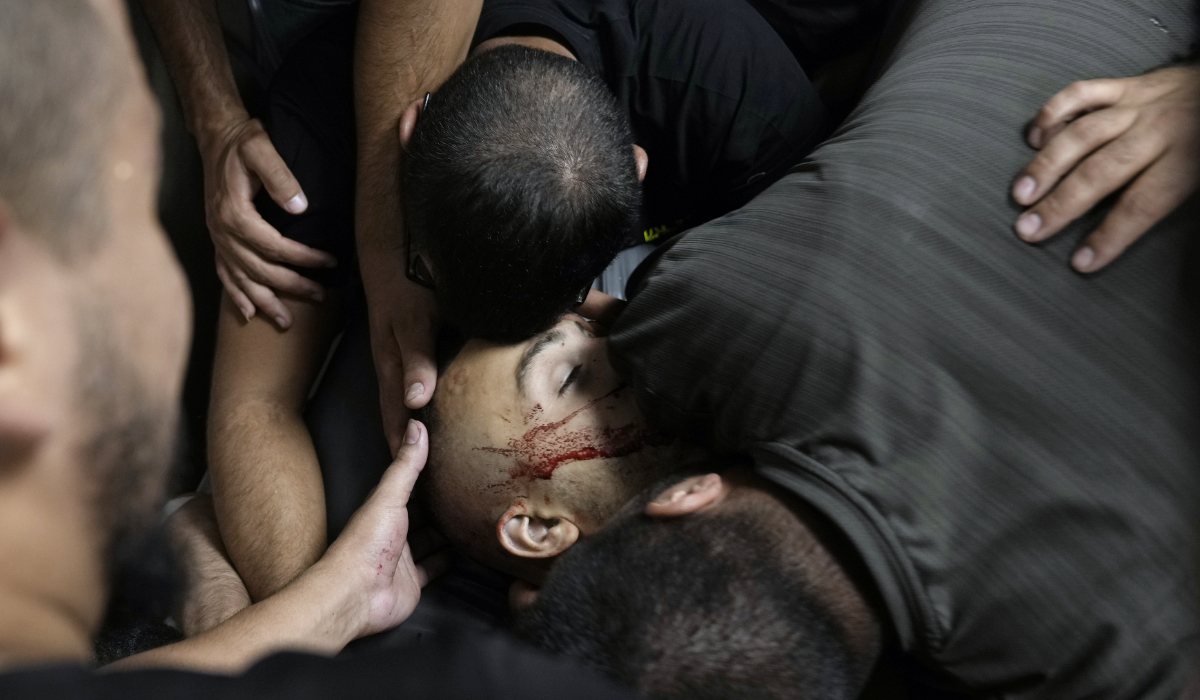 Palestinians mourn over the body of one of three Palestinians killed in clashes with Israeli security forces, in the West Bank city of Jenin, Thursday, June 6, 2024. (AP)