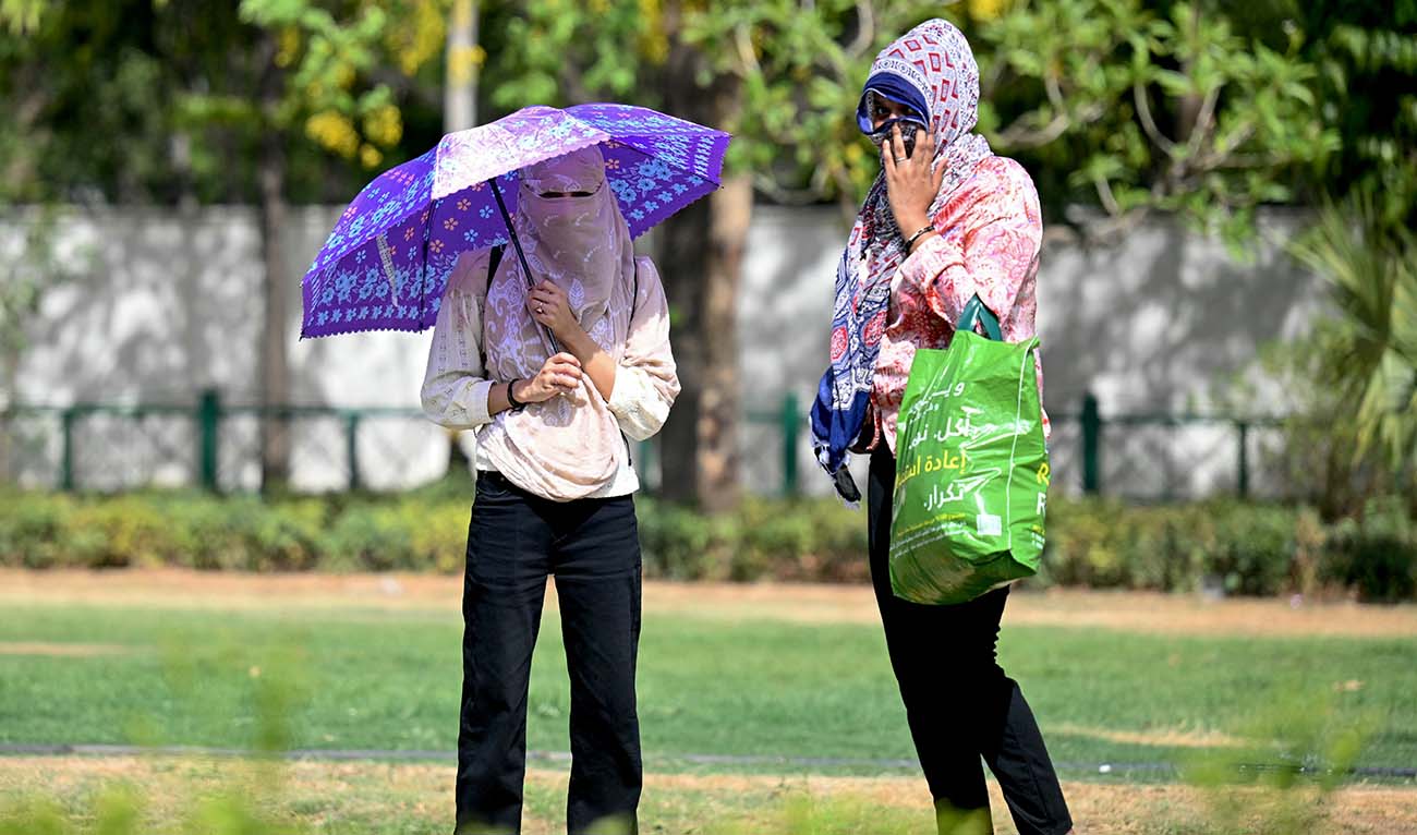 Women wearing scarves walk in a garden on a hot summer day in New Delhi on May 30, 2024, amid ongoing heatwave. India is enduring a crushing heatwave with temperatures in several cities sizzling well above 45 degrees Celsius (104 degrees Fahrenheit). (AFP/File)