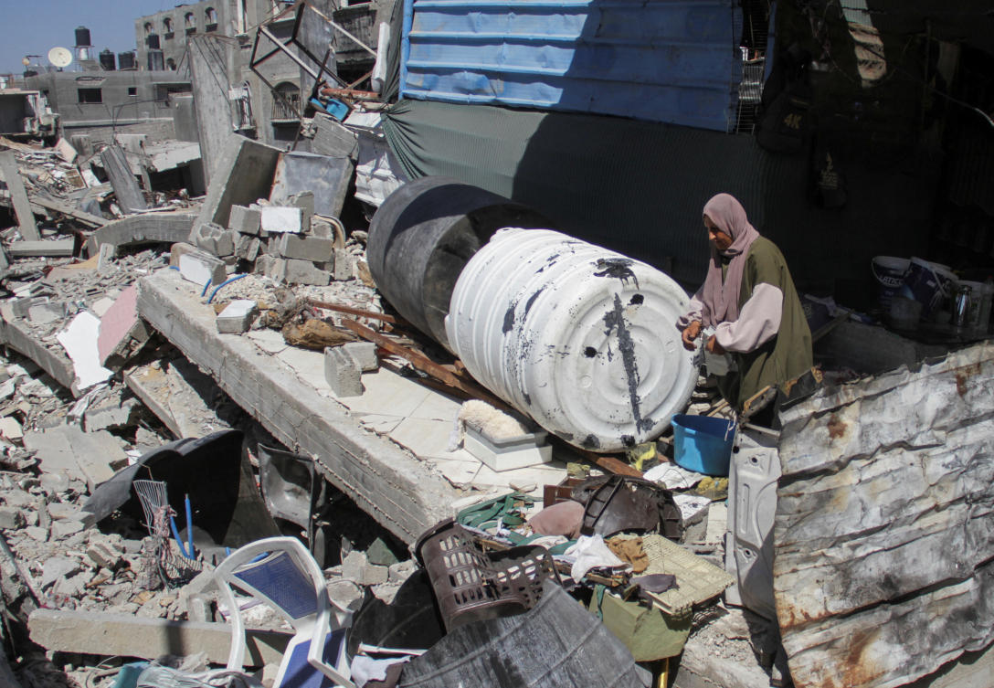 A Palestinian woman stands among the rubble of a damaged building, which was destroyed during Israel's military offensive, amid the ongoing conflict between Israel and Hamas, in Beit Lahia in the northern Gaza Strip, June 12, 2024. (REUTERS)