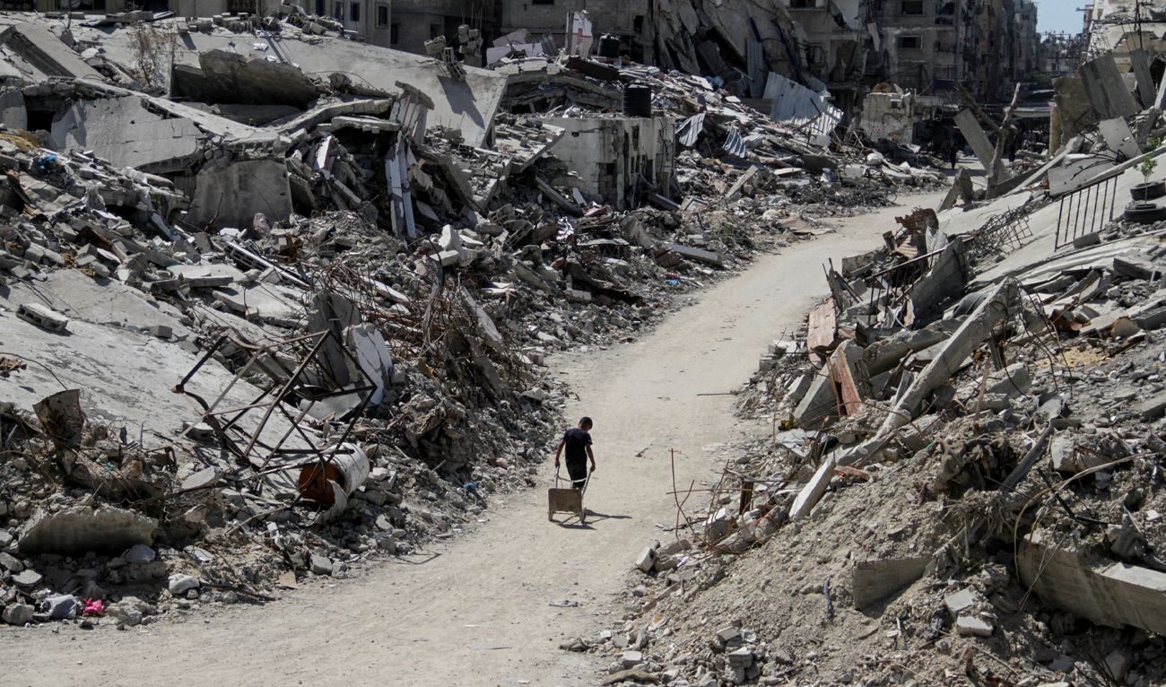 A Palestinian walks among the rubble of damaged buildings, which were destroyed during Israel’s military offensive, amid the ongoing conflict between Israel and Hamas, in Beit Lahia in the northern Gaza Strip, June 12, 2024. (REUTERS)