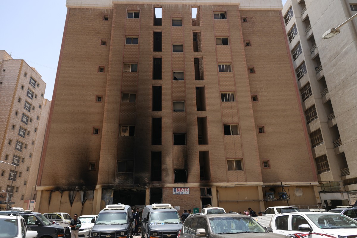 Kuwaiti security forces gather outside a building which was ingulfed by fire, in Kuwait City, on June 12, 2024. More than 35 people were killed and dozens injured in a building fire in an area heavily populated with foreign workers in Kuwait, the interior ministry said.(AFP)