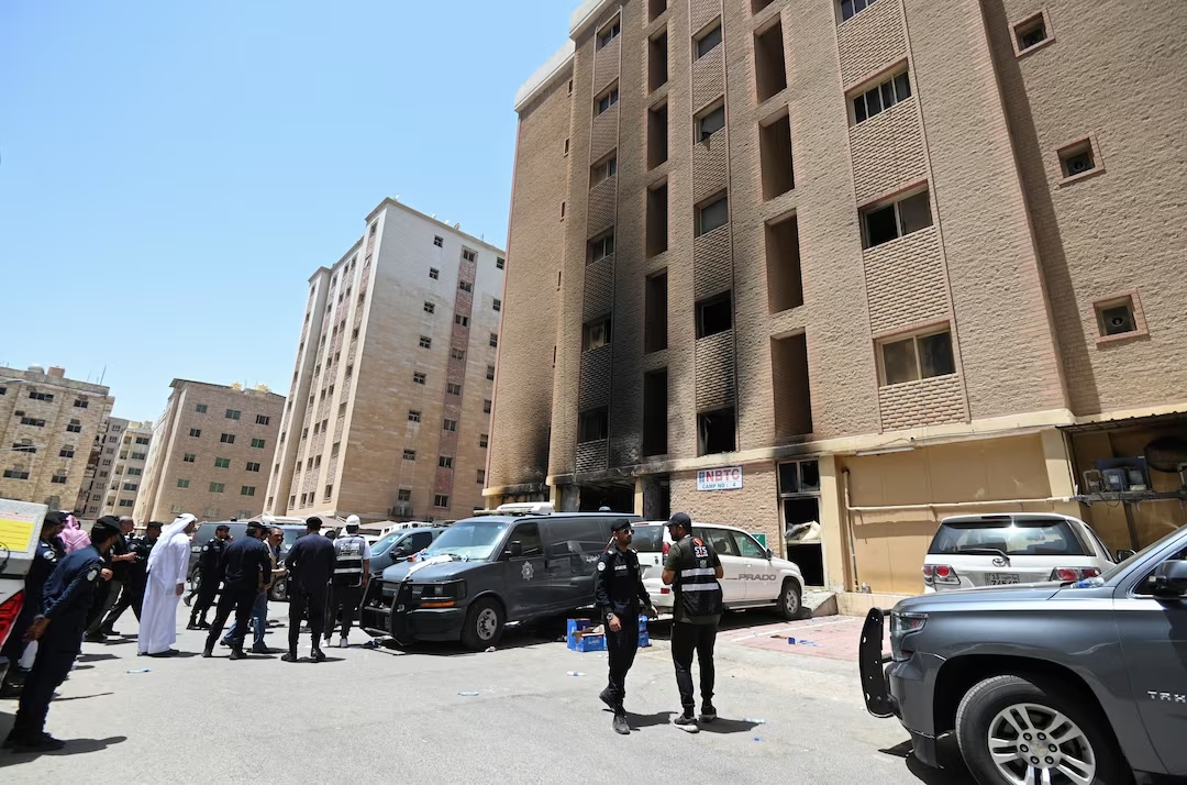 Kuwaiti police officers are seen in front of a burnt building following a deadly fire, in Mangaf, southern Kuwait. (Reuters)